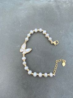 Elevate your jewelry collection with this stunning beaded bracelet featuring beautiful freshwater pearls and a delicate mother-of-pearl butterfly charm. Crafted from high-quality 14k yellow gold plated metal, this bracelet exudes a timeless elegance that's perfect for any occasion. The white pearls and secondary pearl stones add a touch of sophistication to the piece, making it a must-have for any fine jewelry lover. The bracelet is designed in a versatile beaded style, making it easy to pair wi Butterfly Clasp Bracelets For Gift, Butterfly Charm Bracelet Jewelry Gift, Dainty Butterfly Charm Bracelets For Gift, Dainty Butterfly Charm Bracelets As Gifts, Dainty Butterfly Charm Bracelet Gift, Pearl White Pearl Bracelets For Gift, Pearl White Pearl Bracelet As Gift, Pearl White Pearl Bracelet Gift, Elegant Butterfly Bracelets For Gifts