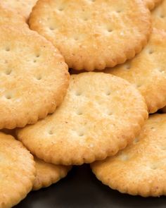 a pile of crackers sitting on top of a black plate next to each other