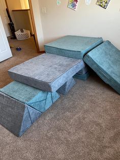 three blue mattresses sitting on top of each other in a room with carpeted flooring