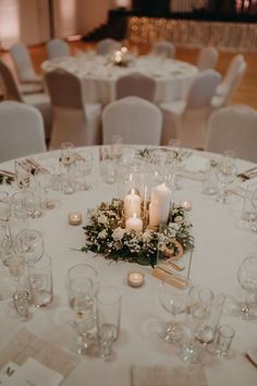 the table is set with candles, flowers and wine glasses for an elegant wedding reception