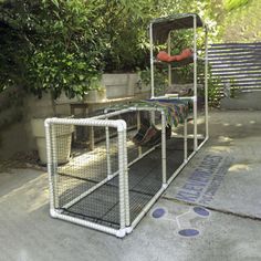 a caged in outdoor area with plants and potted trees on the other side