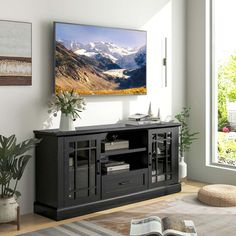 a large flat screen tv mounted to the side of a wooden entertainment center in a living room