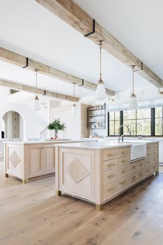 a large kitchen with an island in the middle and lots of cabinets on both sides