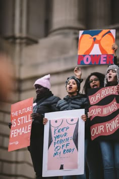 people holding up signs in the air with words on them that read power is still female