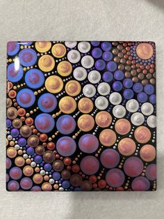 a square tile with circles and dots on it