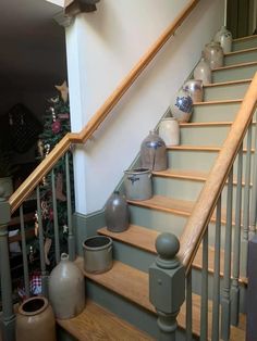 a set of stairs with vases on the bottom and handrail next to it