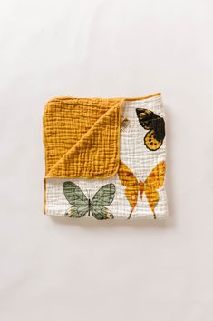 a yellow and white blanket with butterflies on it