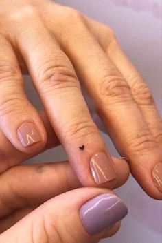 two hands with manies on their fingers and one has a small black dot in the middle