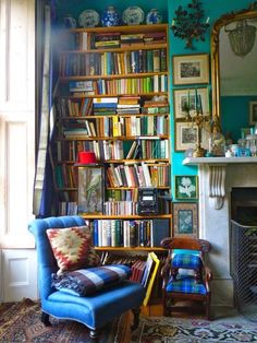 a blue chair sitting in front of a book shelf filled with books