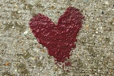 a heart shaped object on the ground with dirt and gravel around it's edges