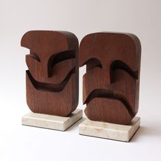 two wooden sculptures made to look like faces