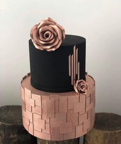 a black and pink cake with flowers on top