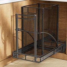 a kitchen cabinet door is open and there are drawers in the bottom drawer that have metal mesh baskets on them