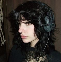 a woman with black hair wearing headphones