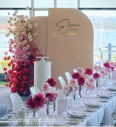 the table is set with white and pink flowers