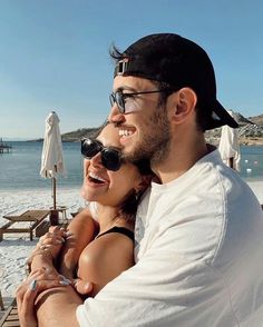 a man and woman are hugging on the beach