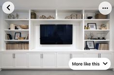 a large white entertainment center with shelves and a flat screen tv mounted on the wall