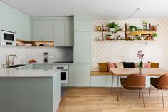 an open kitchen and dining room with white walls, wood floors and wooden flooring