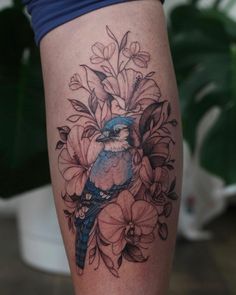 a blue bird sitting on top of a flower filled thigh