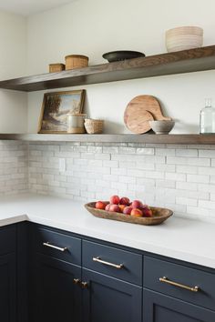 a bowl of fruit sitting on top of a kitchen counter