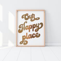 a framed poster with the words only happy place in gold foil on a white wall