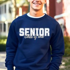 a young man wearing a senior class sweatshirt