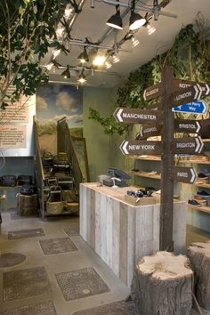 the inside of a store with many signs and trees in it's display area