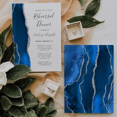 a blue and white wedding suite with matching ring box, napkins, and flowers