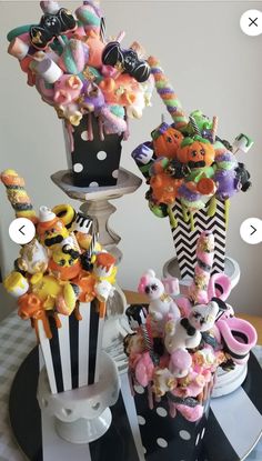 three vases filled with different types of candies and candy on top of a table