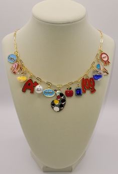 This charm necklace is made with an Italian solid 14k gold over 925 sterling silver paperclip chain. Length: 20 inches long. It holds 13 primarily red, white, blue, yellow, and pink charms of varying sizes and shapes lending to its eclectic feel. This necklace would suit any teacher and/or school personnel looking to jazz up their back-to-school outfits. Charms: Lucky, backpack, confetti ball, A+, pearl, good, paint palette, apple, blue gemstone, 100, blue confetti call, right angle, best award. Pink Charms, Blue Confetti, Teacher Back To School, Pink Charm, Charm School, Back To, Charm Necklaces, Paint Palette, Blue Gemstones