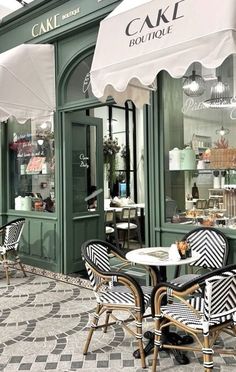 the outside of a cafe with tables and chairs under an awning that reads cake boutique