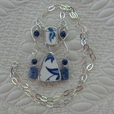 a blue and white necklace with charms on it