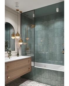 a bathroom with green tile and gold fixtures