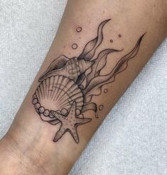 a black and white photo of a sea shell tattoo on the left leg, with an ocean wave coming out of it