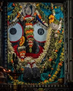 an elaborately decorated mask is hanging on the wall