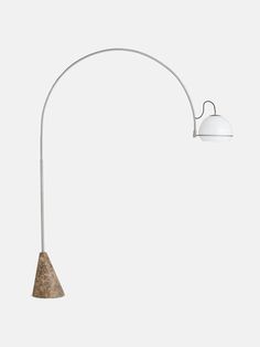 a lamp that is on top of a white wall next to a light fixture with an arm