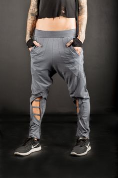 Urban low crotch Baggy Trousers/Cyberpunk women's low crotch pants/post apocalyptic baggy pants/Futuristic low crotch pants Baggy low waist pants. Decorated with stitching at the back and asymmetric ending . Pockets and big openings with straps at the front,calves exposing. Made of cotton Lycra and elastic at the waist fits better on many body types. A necessary piece for those sworn to street-fashion! A pair of pants that stands out,no need to make any effort for your appearance with this desig Techwear Harem Pants, Baggy Techwear Harem Pants, Cyberpunk Baggy Bottoms For Streetwear, Baggy Cyberpunk Bottoms For Streetwear, Baggy Cotton Bottoms For Cosplay, Baggy Drop Crotch Bottoms For Festival, Baggy Techwear Pants For Alternative Fashion, Futuristic Pants, Hose Post