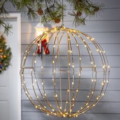 a christmas ornament hanging from the side of a house with lights on it