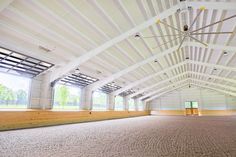 an empty room with wooden floors and large windows in the ceiling is seen from across the room