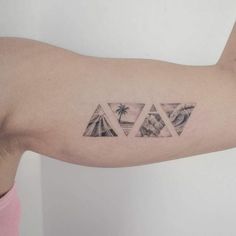 a man's arm with three triangles and palm trees on the left side of his arm