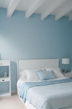 a bedroom with blue walls and white furniture