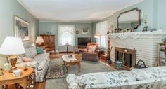 a living room filled with furniture and a fire place in the middle of a room