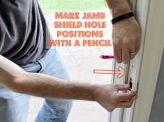 a man opening a door with the words mark jamb shield hole positions with a pencil