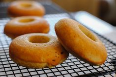 three doughnuts sitting on top of a cooling rack next to eachother