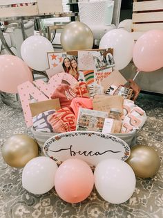 a basket filled with balloons and pictures on top of a table next to other items