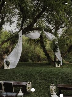 an outdoor wedding setup with white drapes and chairs