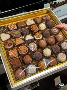 a person holding a box of assorted chocolates