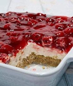 a cake in a white dish with cherries on top