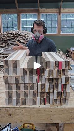 a man wearing headphones standing in front of wooden blocks