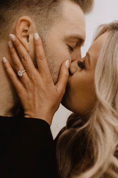 a man and woman kissing each other in front of a mirror